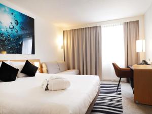 a hotel room with two beds and a desk at Novotel Antwerpen - Ekeren in Antwerp
