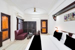 a bedroom with a bed and a couch and a chair at HOTEL O 4 SQUARE A LUXURY ROOMS NEAR RDC MAIN MARKET in Ghaziabad +29 photos