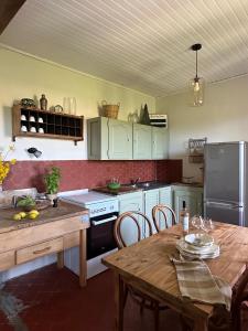 a kitchen with a table and a refrigerator and a stove at Le Grand Gîte in Vaison-la-Romaine