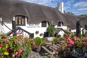 a building with a bunch of flowers in front of it at The Cott Inn in Totnes