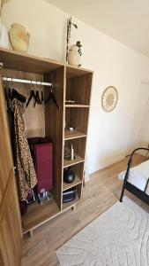 a room with a wooden book shelf with clothes at Ker Bellevue, chambre Dinan in Lanvallay