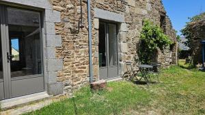 a stone building with a table next to a window at Ker Bellevue, chambre Dinan in Lanvallay
