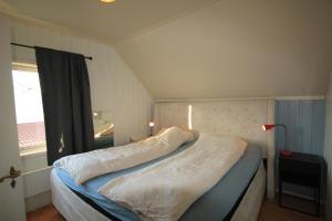 a small bedroom with a bed with a window at Smia in Søgne +37 photos