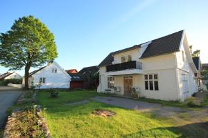 a white house with a tree and a yard at Smia in Søgne