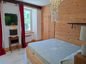 a bedroom with a bed and a window at Duplex au coeur d'Embrun in Embrun