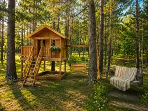 a tree house in the woods with a bench at Magiczny Dom nad Bugiem in Pętkowo Wielkie