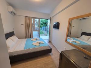 a bedroom with two beds and a large mirror at Vasiliki Apts in Vasiliki