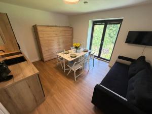 a living room with a table and a couch at AVA apartmán Javorná na Šumavě in Čachrov