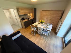 a living room and kitchen with a table and a couch at AVA apartmán Javorná na Šumavě in Čachrov