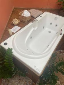 a white bath tub sitting inside of a bathroom at Pousada Viva Paraíso in Alto Paraíso de Goiás +61 photos