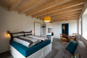 a bedroom with a bed and a dining room at Maison d hôtes Les Bruyères in Bonvillars