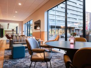 a waiting room with a table and chairs at Novotel Amsterdam City in Amsterdam