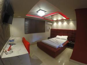a bedroom with a bed and a table in it at Motel Tenda in Maringá