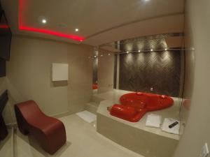 a bathroom with a red sink and a red chair at Motel Tenda in Maringá
