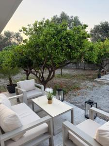 a patio with couches and tables and a tree at Villa Lonaki in Haraki +6 photos