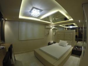 a bedroom with a bed and a lighted ceiling at Motel Tenda in Maringá