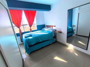 a bedroom with a bed with a mirror and a window at Apto 3 dormitorios cerca al mar B in Pacasmayo