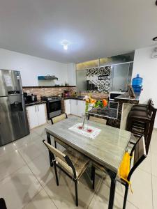 a kitchen with a table and chairs and a refrigerator at Apto 3 dormitorios cerca al mar B in Pacasmayo