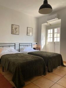 a bedroom with two beds and a window at Casa Jazmin in Alora