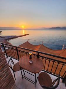 a table and chairs on a balcony with a sunset at Blue Sea Suite Avlakia in Avlákia