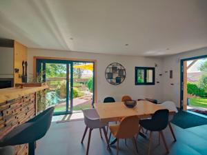a kitchen and dining room with a wooden table and chairs at À la Volette - Cosy, Nature & Miel des Vosges in Plombières-les-Bains