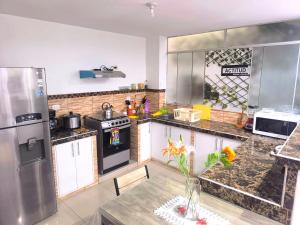 a kitchen with stainless steel appliances and a table at Apto 3 dormitorios cerca al mar B in Pacasmayo +13 photos