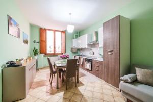 a kitchen with green walls and a table and chairs at La Casetta del Suffragio in Viterbo