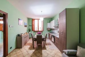 a kitchen and dining room with green walls and a table and chairs at La Casetta del Suffragio in Viterbo +20 photos
