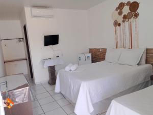 a hotel room with a bed and a sink at Torre do Sol in Praia do Frances