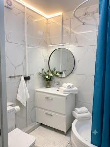 a white bathroom with a sink and a mirror at Lizz-Hotel in Chişinău