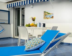 a dining room with a blue table and chairs at Grecale - stunning sea-view apartment with patio, up to 5 guests in Maiori