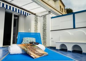 a blue chair on a porch with a table at Grecale - stunning sea-view apartment with patio, up to 5 guests in Maiori