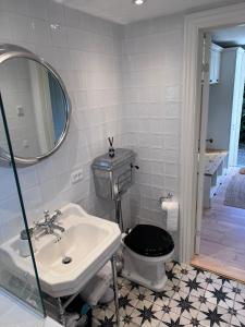 a bathroom with a sink and a toilet with a mirror at The Copenhagen Retreat in Hvidovre +18 photos