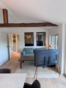 a living room with a blue couch and a tv at The Copenhagen Retreat in Hvidovre