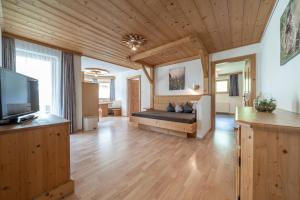 a large living room with a couch and a television at Replers Hotel garni & Appartements in Prägraten