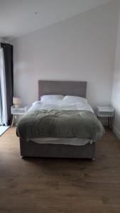 a bed in a bedroom with two nightstands and two tables at Spacious Bungalow in Beeston in Nottingham