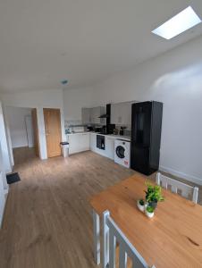 a kitchen with a wooden table and a black refrigerator at Spacious Bungalow in Beeston in Nottingham