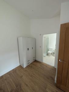 an empty room with a white cabinet and a mirror at Spacious Bungalow in Beeston in Nottingham