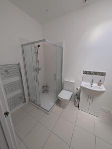 a bathroom with a shower and a toilet and a sink at Spacious Bungalow in Beeston in Nottingham