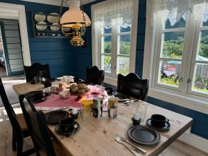 a dining room with blue walls and a wooden table at Horgheim Boutique Lodge, Romsdalen in Åndalsnes +13 photos
