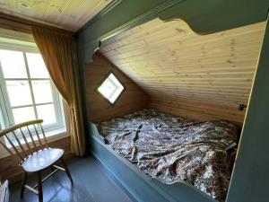 a bed in a wooden room with a window at Horgheim Boutique Lodge, Romsdalen in Åndalsnes