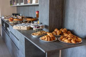 a buffet line with various types of bread and pastries at B&B Abbazia di Piona in Colico +20 photos