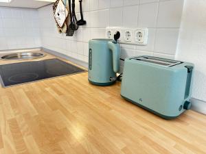 a toaster sitting on a wooden floor in a kitchen at Ferienwohnung mit Kamin - Hunde willkommen in Falkenstein