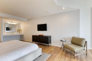 a bedroom with a bed and a chair and a television at The Mara Laguna Beach, an AvantStay Hotel in Laguna Beach