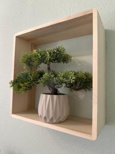 a plant in a white vase on a shelf at Ferienwohnung mit Kamin - Hunde willkommen in Falkenstein