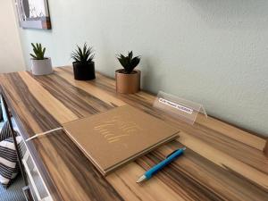 a book on a desk with a pen and plants at Ferienwohnung mit Kamin - Hunde willkommen in Falkenstein