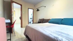 a bedroom with a large bed and a living room at Casa Inteira com Garagem, no Goiabal até 3 hospedes in Macapá