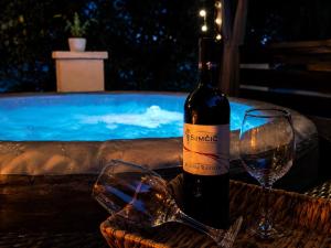 a bottle of wine and a glass next to a swimming pool at Luxury House Cesarica in Cesarica