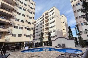 two tall apartment buildings with a pool in front of them at Vossa Bossa Olimpia in Olímpia