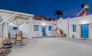 a patio with blue doors and white buildings at Houch ZanZouri in Houmt Souk